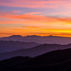 Majestic Mountain Range at Sunset with Vibrant Sky.