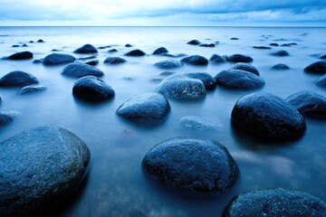 Calm sea, smooth stones, blue hues, long exposure