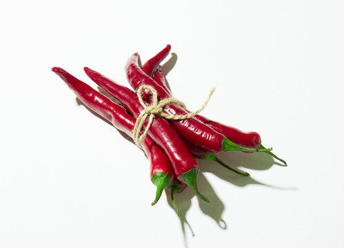 Many red chilli pepers with rope isolated on a white