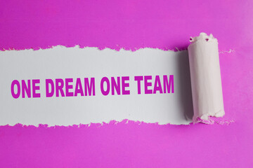 One dream one team Text written in torn paper