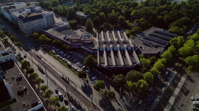 Sez and Volkspark Friedrichshain in Berlin, showcasing its lush greenery, a passing tram on a sunny day. Magic aerial view flight drone shot from above