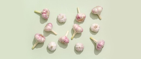 Many fresh garlic on green background, top view