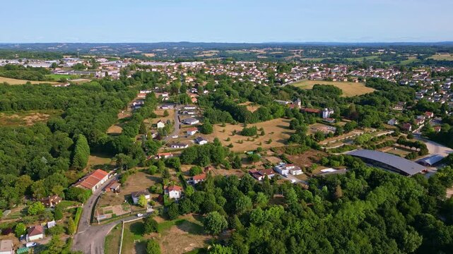 Panorama drone fly about the countryside part of Saint-Junien town with scattered houses and forested environment, Haute-Vienne, France. Drone forward