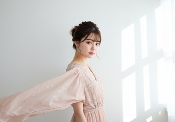 Young woman with dark hair styled up wearing a light beige kimono and pink top