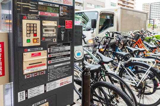 Automated bicycle parking payment machine in Osaka city Japan with bicycles parked in the background, modern urban transportation system.