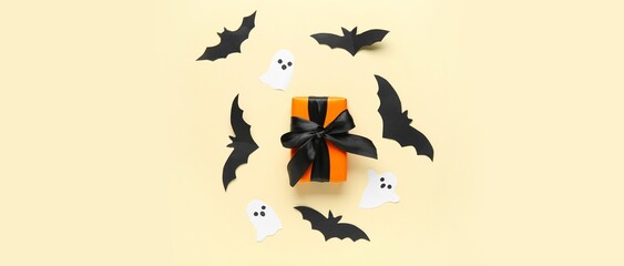 Halloween gift with paper bats and ghosts on beige background