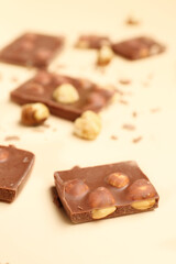Sweet tasty chocolate with nuts on  beige background