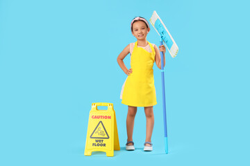 Cute little janitor with mop and caution sign on blue background