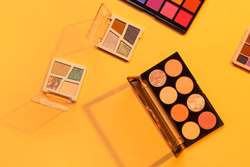 Beautiful palettes of eyeshadows on orange background