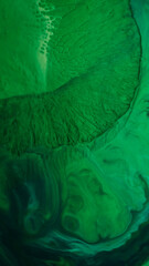 Ink fluid flow. Paint liquid. Defocused green color splash water shine sparkle creative wet texture on abstract art acrylic background.