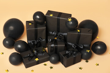 Gift boxes with balloons and confetti on beige background. Black Friday sale