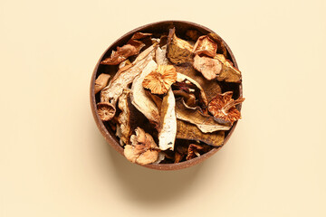 Brown bowl with tasty dried mushrooms on yellow background