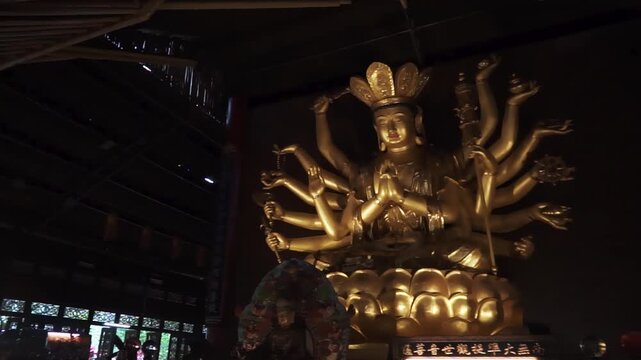 Golden sculpture of Avalokiteshvara Buddha or Guanyin with thousand hands at Putuo Village in Malaysia.