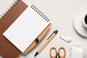 Notebook, stationery and earphones on white background