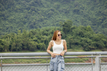 young woman standing on a bridge