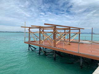 Construction of a Wooden Pier Over Turquoise Waters with Open Skies