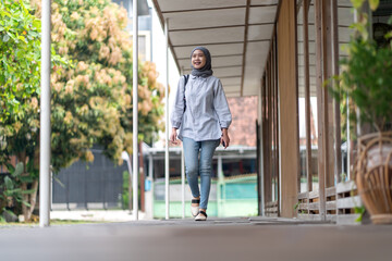 Indonesian Muslim woman walking outdoors with confidence