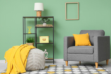 Interior of living room with cozy armchair, lamp and shelving unit