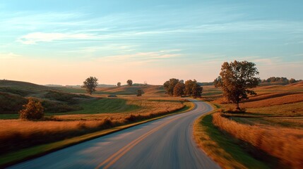 Obraz premium An open road winds its way through a picturesque rural landscape at sunset