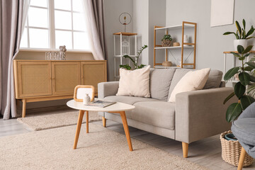 Interior of living room with sofa, commode and curtains on window