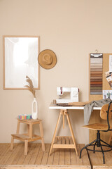Interior of stylish atelier with tailor's workspace, sewing machine and mood board