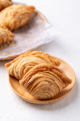 Curry puff stuffed with chicken or sweet potatoes on wooden plate with white background, Thai snack food style
