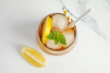 Glass of Long Island iced tea cocktail with mint on white background