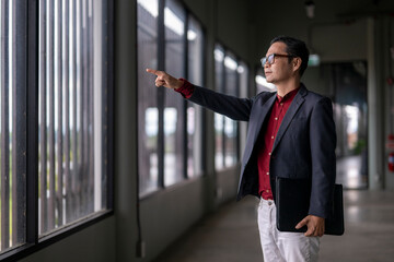 Fototapeta premium Architect pointing at new building project through window