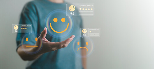 Customer satisfaction rating concept with hand choosing different review and emoticons, feedback...