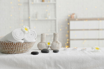 Composition with spa accessories and tropical flowers on massage table in salon