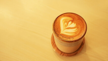 A cup of hot latte coffee on the table for breakfast