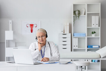 Female doctor with headset and laptop giving online consultation in clinic
