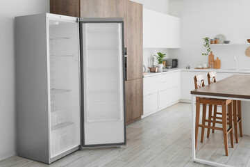 Interior of kitchen with empty fridge, table and counters