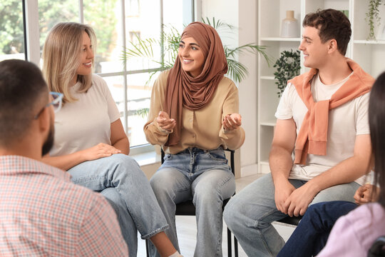 Young Muslim woman talking at group therapy session - Powered by Adobe