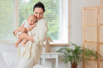 Young mother with her little baby in bedroom. IVF concept