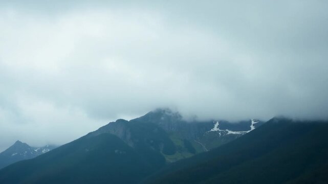 A misty mountain range under a cloudy sky