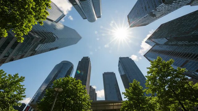 Looking up at modern skyscrapers against a clear blue sky