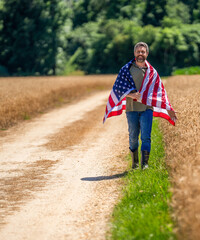 Man with American flag in crop field. Independence day of America. 4th July. American labor day....