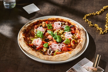 Grilled vegetable pizza with onions, bright natural light, overhead rustic tabletop composition
