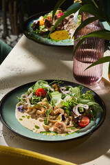 Warm squid salad with creamy sauce, cherry tomatoes, moody lighting, overhead composition