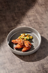Buffalo chicken wings with eggplant, bright lighting, minimal overhead composition