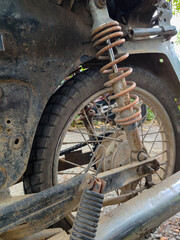close up of a dirty rear shock absorber on a motorbike