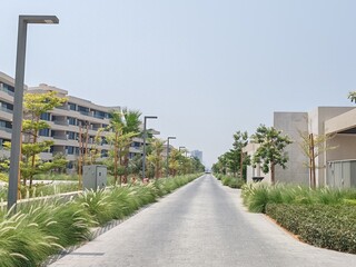 Villa's Or Houses With Their Cream Color Design And Front Side Outdoor View. Green Landscaping With Washingtonia Trees At Front Side Of Villa's. Interlock Road Passing At Front Of The Villa's