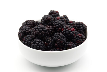 A bowl overflowing with fresh, dark, ripe blackberries, glistening with tiny water droplets, presented on a clean white background.