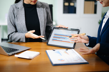 Business team collaboration discussing working analyzing with financial data and marketing growth report graph in team, presentation and digital tablet, laptop.