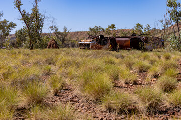 An old car in the Australian bush, rusty and abandoned.