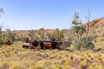An old car in the Australian bush, rusty and abandoned.