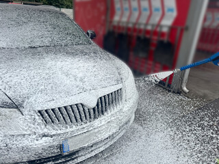 A man washes his car in a self-service sink.