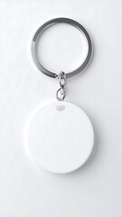 A simple, blank, white circular keychain tag hangs from a polished metal ring against a plain white background.