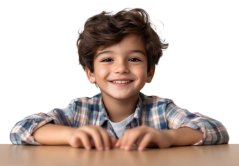 a cute little boy sitting at a desk, smiling and looking forward with his hands on top of it, against a transparent background